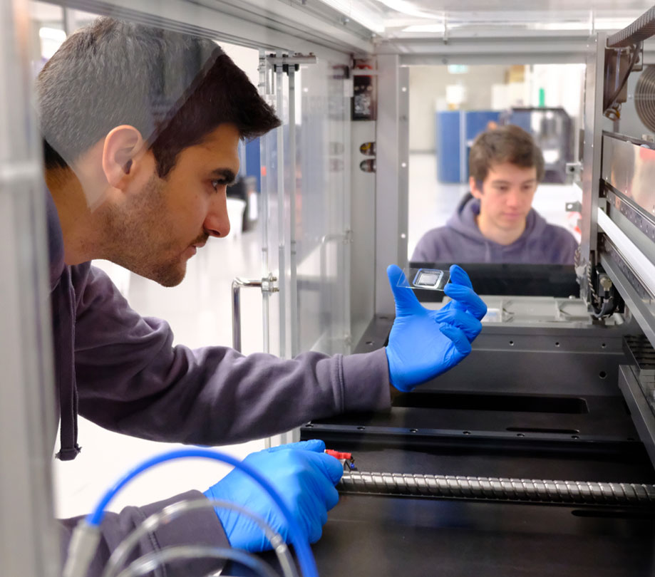 Daniel Nakhaee Zadeh inspecting microfluidic chip to test thousands of AI generated proteins
