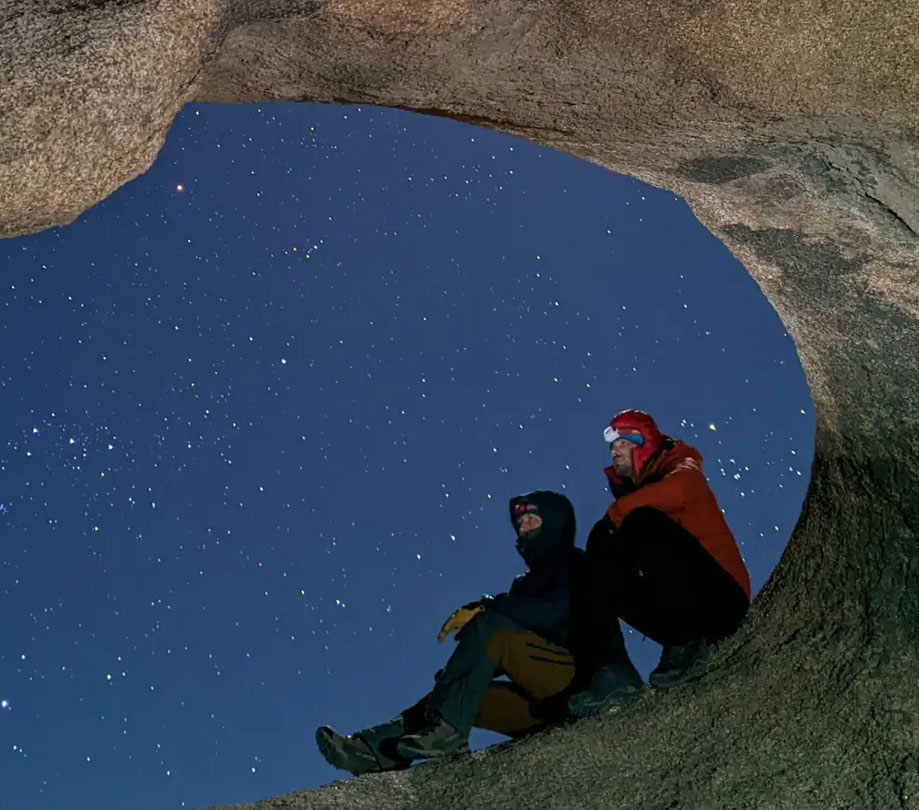 Two hikers under a starlit sky captured using Night Sight on a Google Pixel phone